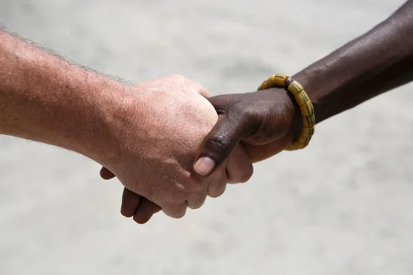 Handdruk tussen een blanke en een Afrikaanse — Stockfoto