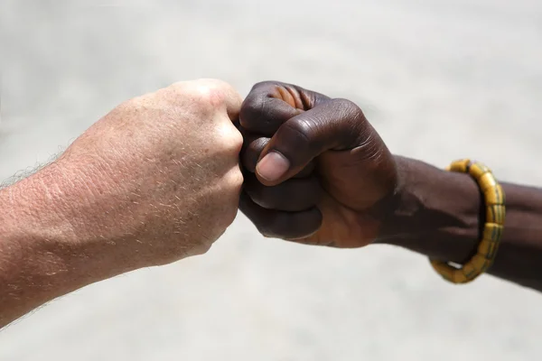 Hand greeting between a Caucasian and an African — Stock Photo, Image