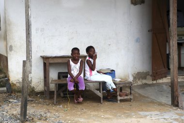 Afrikalı kız evinin önünde oturmak