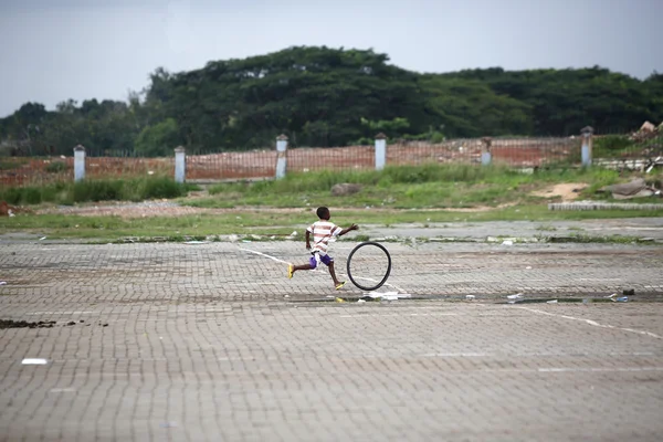 Африканский мальчик играет с шиной — стоковое фото