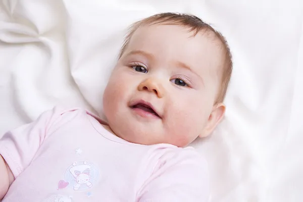 Babymeisje kijkt in de camera — Stockfoto