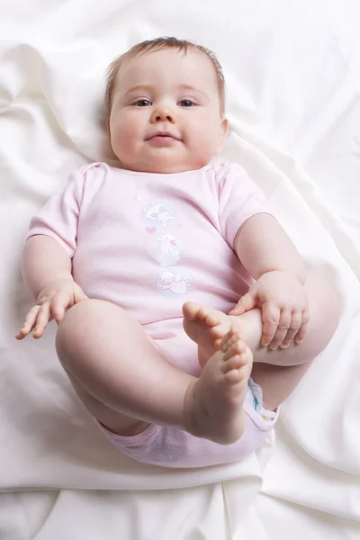 Babymeisje kijkt in de camera — Stockfoto