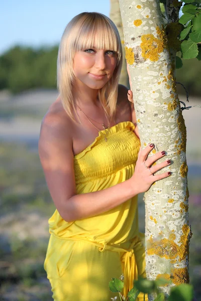 Beautiful blonde near a tree — Stock Photo, Image