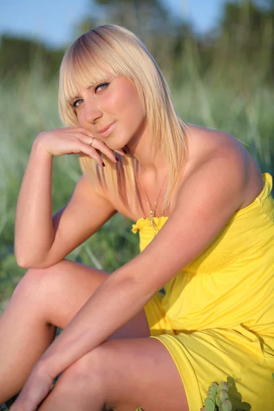 Beautiful blonde on a background of grass Royalty Free Stock Images