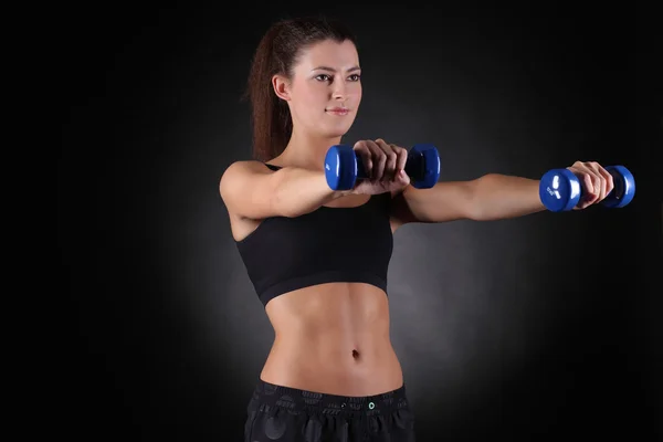 Hermosa deportista musculosa mujer haciendo ejercicio con mancuernas — Foto de Stock