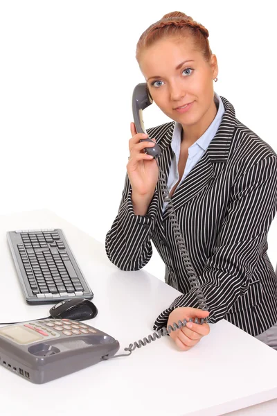 Young business woman on phone while using computer at workplace — Stock Photo, Image