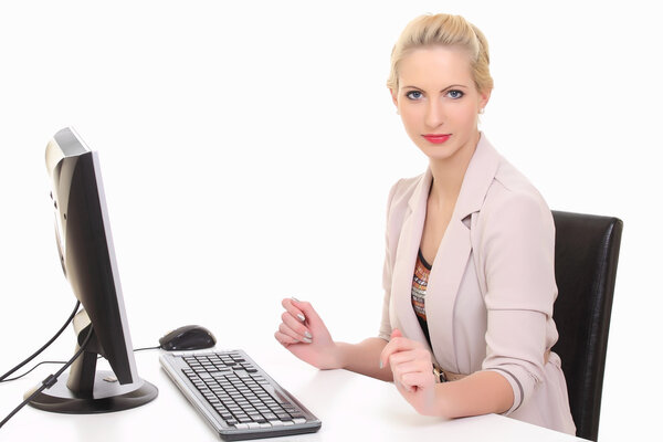 Businesswoman working on a computer at her office desk isolated against a white background.