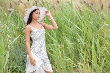 uzun otların bir arka plan üzerinde beyaz elbiseli genç kadın