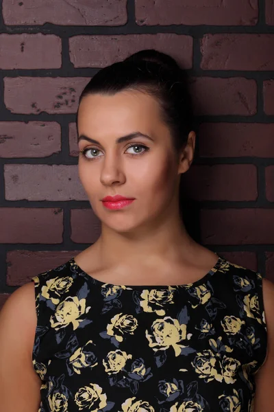 Beautiful brunette against the wall — Stock Photo, Image