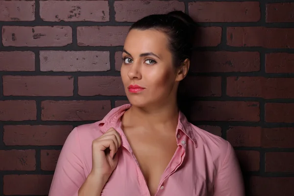 Beautiful brunette against the wall — Stock Photo, Image