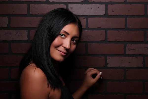 Beautiful brunette against the wall — Stock Photo, Image