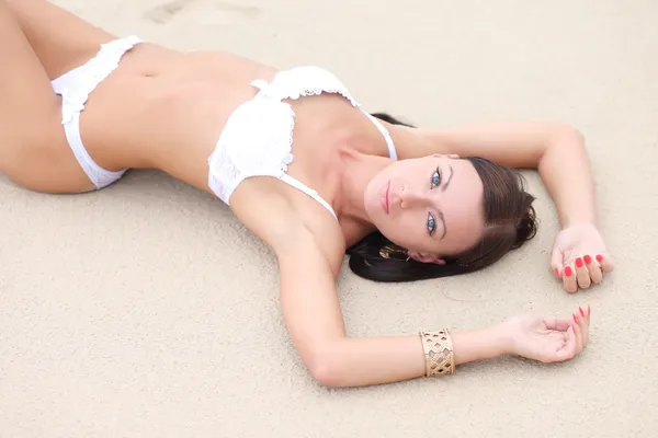 Эротическая женщина лежит на песке — стоковое фото
