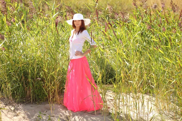 Chica en un sombrero en un paisaje de verano de fondo —  Fotos de Stock