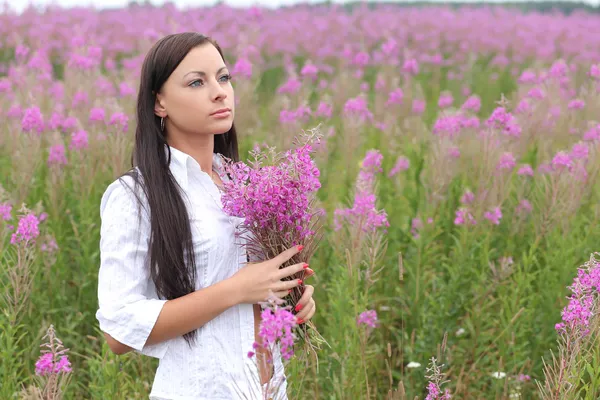 在高高的草丛背景上的白色连衣裙的年轻女子 — 图库照片