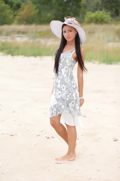背の高い草の背景に白いドレスを着た若い女性 — ストック写真