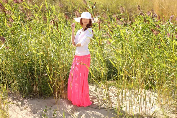 Chica en un sombrero en un paisaje de verano de fondo —  Fotos de Stock