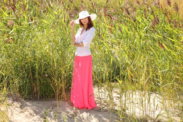 Chica en un sombrero en un paisaje de verano de fondo — Foto de Stock