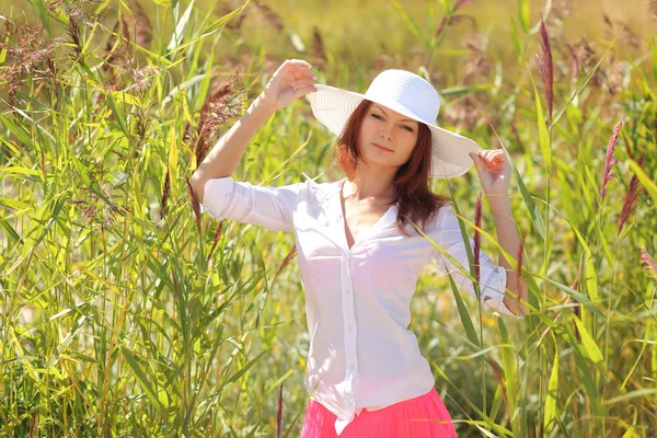 Κορίτσι σε ένα καπέλο σε ένα τοπίο με φόντο το καλοκαίρι — Φωτογραφία Αρχείου