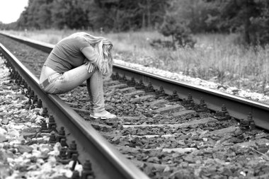 Kızgın kız raylarda oturuyor.