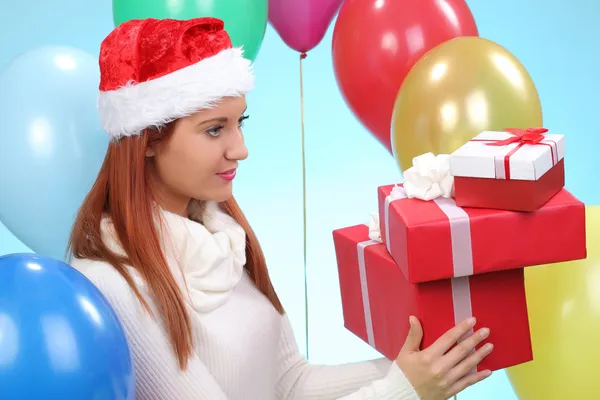 Chica feliz en rojo Santa sombrero celebración caja de regalo —  Fotos de Stock