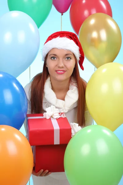 Chica con regalos en la mano, sobre el fondo de las bolas inflables —  Fotos de Stock