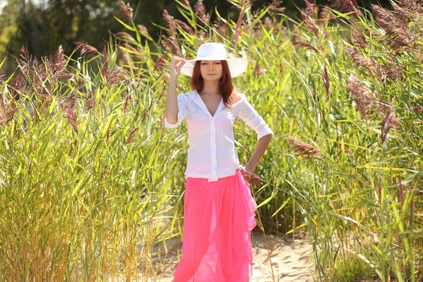 Dívka v klobouku na pozadí letní krajina — Stock fotografie