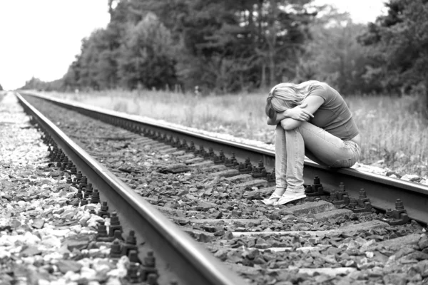 Feldúlt lány ül a síneken. — Stock Fotó