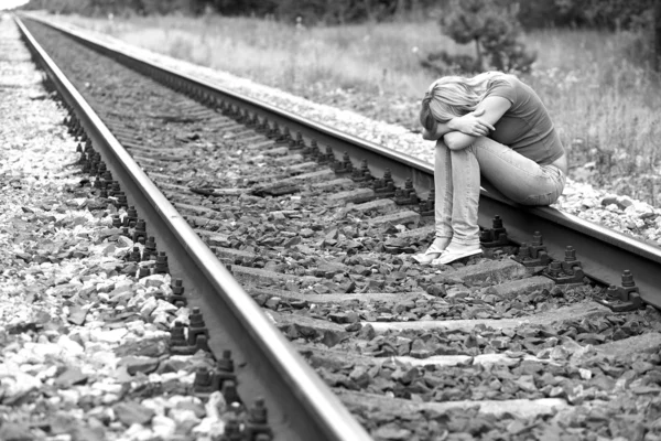 Upset girl sitting on the rails — Stock Photo, Image