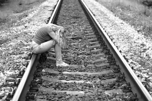 Upset girl sitting on the rails — Stock Photo, Image