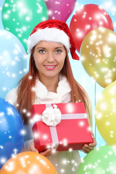Menina bonita vestida de Papai Noel com uma caixa de presente — Fotografia de Stock