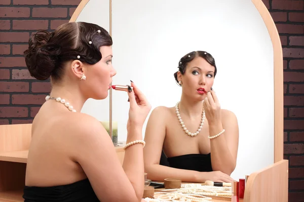 Dziewczyna dostaje makijaż w pobliżu lustro — Zdjęcie stockowe