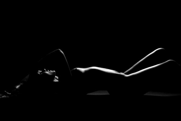 Naked female body on a black background
