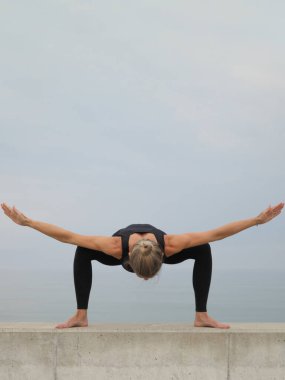 Spor kıyafetleriyle dışarıda egzersiz yapan güzel genç bir kadın.