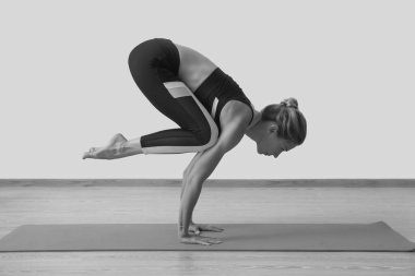 Genç kadın yoga öğretmeni stüdyoda çalışıyor.