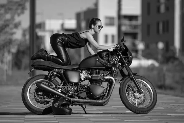 黑色摩托车上迷人的年轻女子的画像 — 图库照片