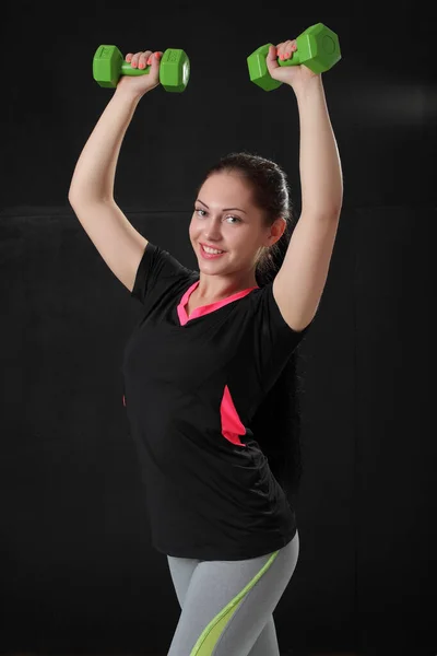 Sportowa Młoda Kobieta Robi Trening Ciężarkami Ciemnym Tle — Zdjęcie stockowe