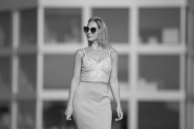 Deniz kenarındaki genç, narin kadın. Kıyafetler içinde poz veriyor.