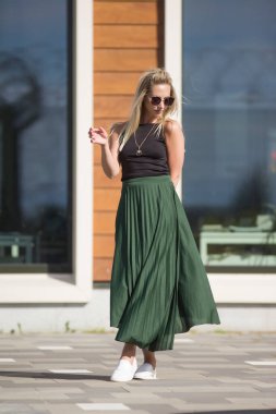 Deniz kenarındaki genç, narin kadın. Kıyafetler içinde poz veriyor.