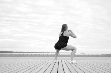 Genç atletik sağlıklı kadın deniz kenarında yoga yapıyor.
