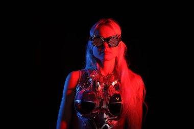 Siyah arka planda gözlüklü genç bir kadının portresi.