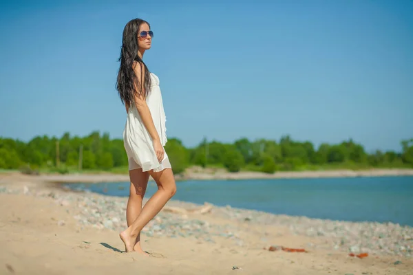 一位身材苗条的年轻女子站在海边穿衣服 — 图库照片