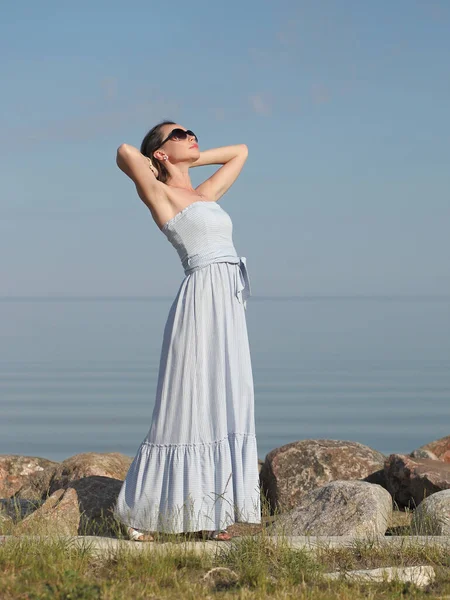 一位身材苗条的年轻女子站在海边穿衣服 — 图库照片