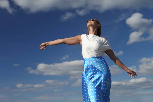 young slender woman by the sea posing in clothes