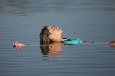 Plajda mayo giymiş genç ve güzel bir kadın