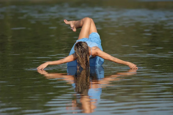 young slender woman by the sea posing in clothes