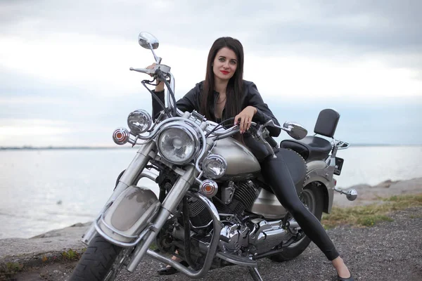 Portrait of charming young woman on motorcycle