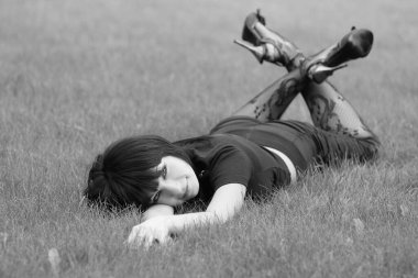 Genç, güzel, kısa saçlı esmer kadın merdivenlerde oturuyor.