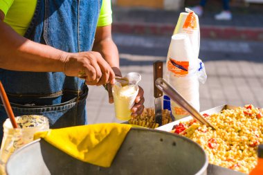 Esquites 'i tek kullanımlık bir bardakta servis etmek, geleneksel Meksika sokak yemekleri..