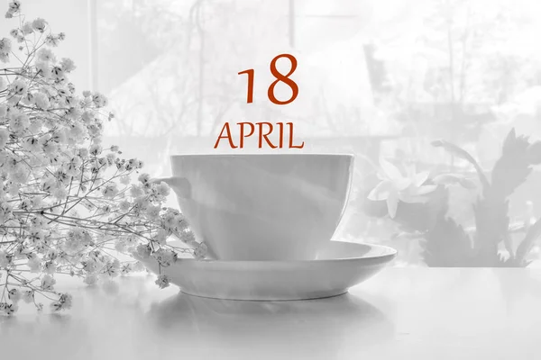 Kalenderdatum auf hellem Hintergrund mit weißem Teepaar aus Porzellan und weißer Gipsophila mit Kopierraum. 18. April ist der achtzehnte Tag des Monats — Stockfoto