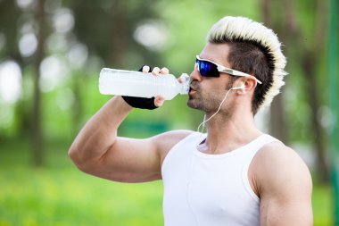 atletik olgun adam içme suyu bir şişe